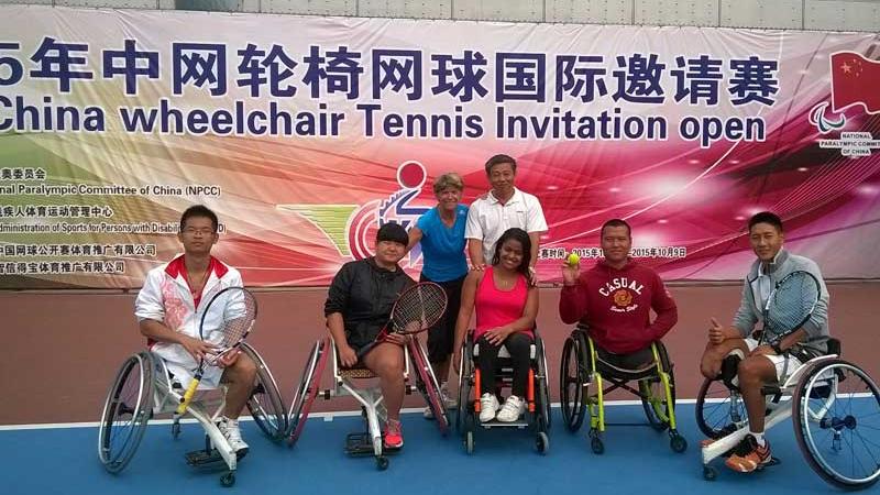 Group picture on a tennis court with some people in wheelchairs