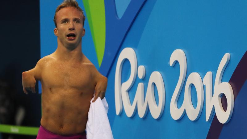 Male swimmer celebrates on pool deck