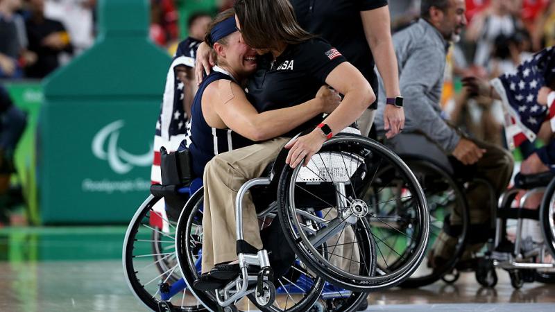 Two women in wheelchairs hugging each other