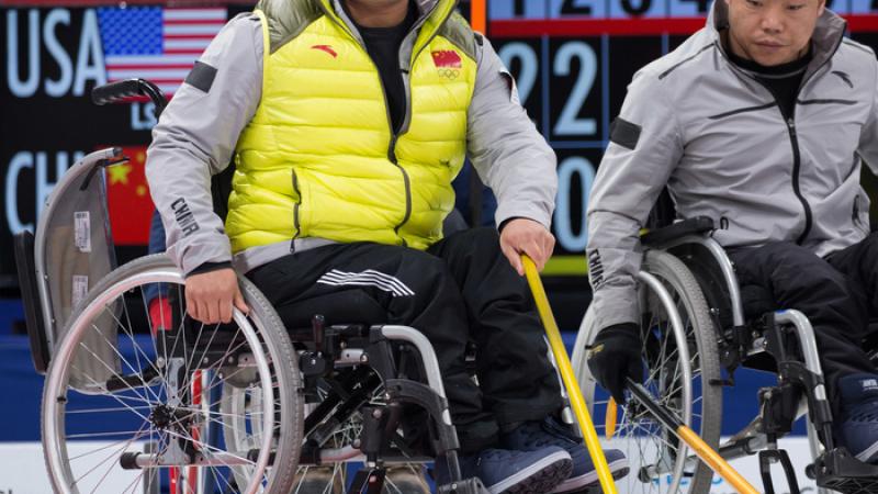 Chinese wheelchair curling players watching the stones