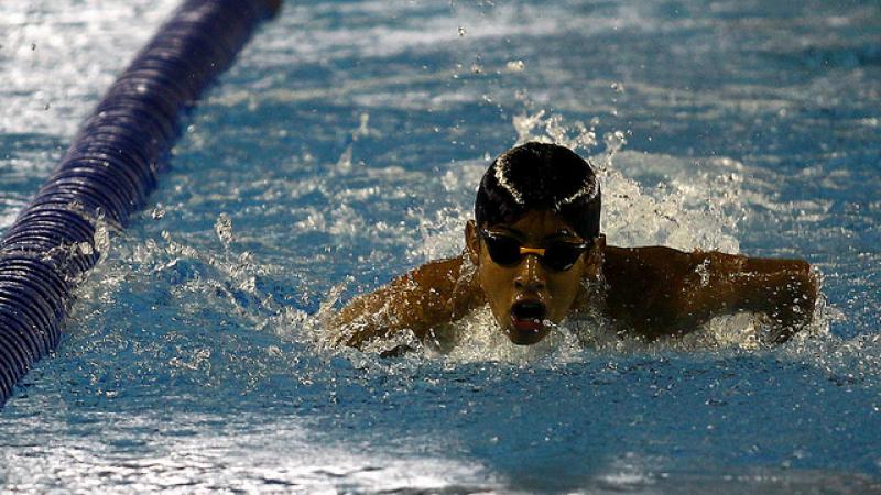 Boy with swim cap and goggles swims