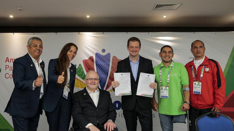 People pose for photo after a partnership agreement is signed