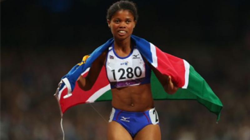 Johanna Benson A picture of a woman running with a Namibian flag on her shoulder