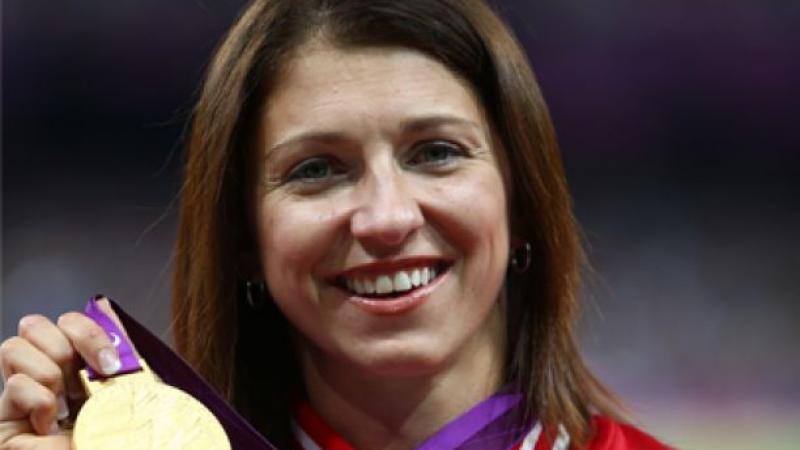 A picture of a woman showing her gold medal