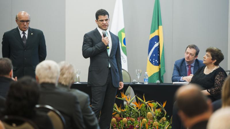 Man with visual impairment holds microphone and speak in front of people