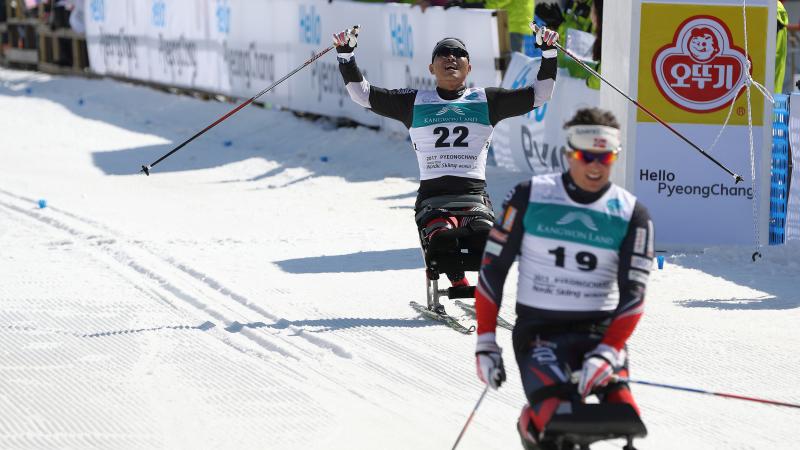 A sit skier celebrates his performance