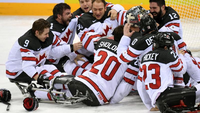 A group of Para ice hockey players celebrating.