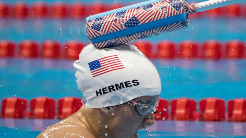 Tapper taps a visually impaired swimmer on the head