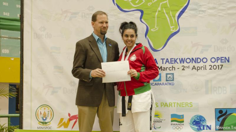 Morocco's Rajae Akermach - taekwondo Woman holds sign with a man