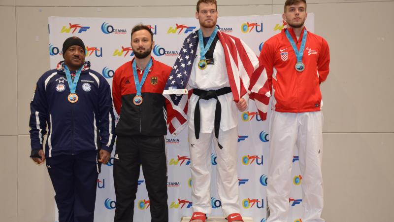 Taekwondo men standing on podium