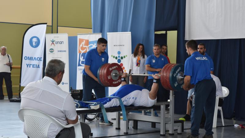 man powerlifting weights on bench