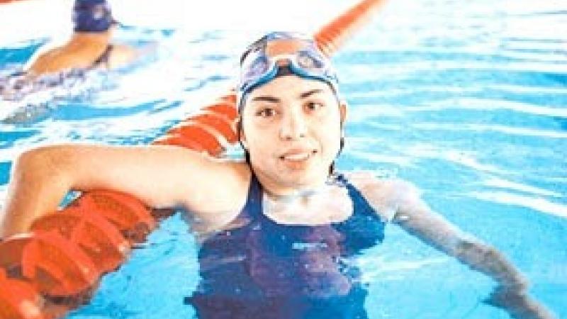 female swimmer celebrates in pool after winning race