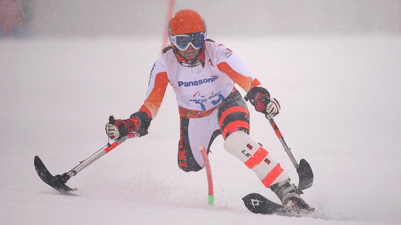 female alpine skier slaloms through gate