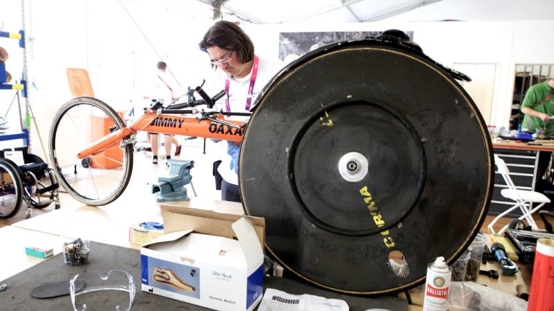 men repairing racing wheelchair