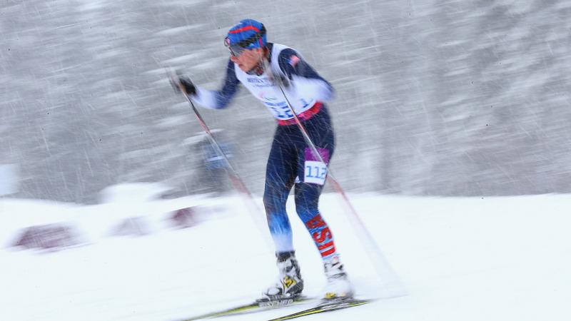 a man uses skies and poles to get across the snow