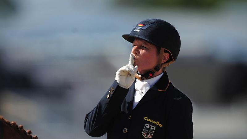 A female rider puts her finger to her lips