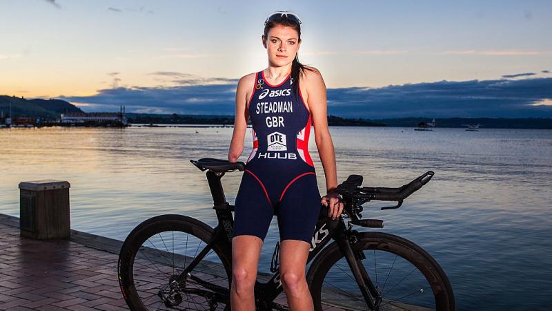 a female triathlete poses for the camera on her bike