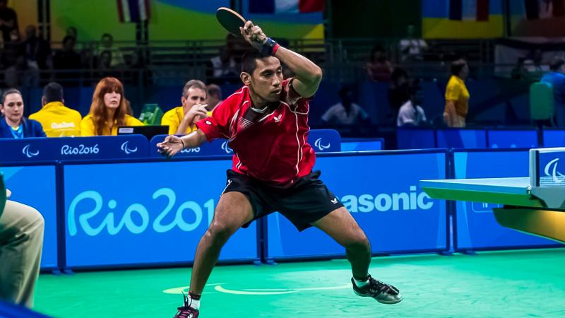 a para table tennis player hits the ball across the net