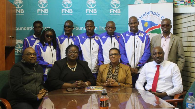 a group of Para athletes and officials pose for a photo