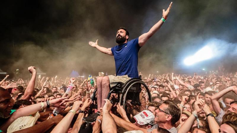 a man in a wheelchair crowd surfs