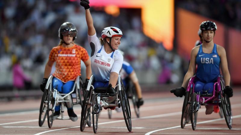 a wheelchair racer celebrates winning a race
