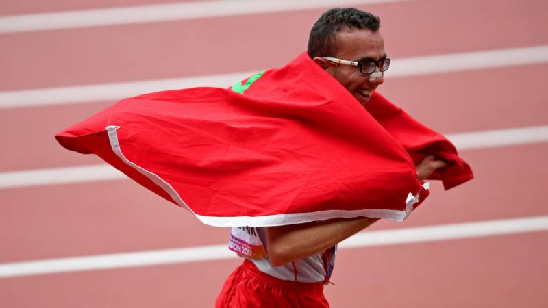 Man in running clothes celebrates with Morocco flag