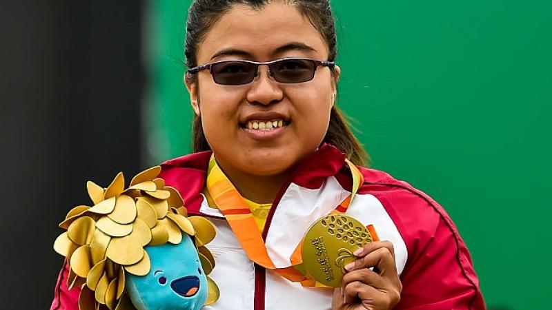 a para archer celebrates with her gold medal