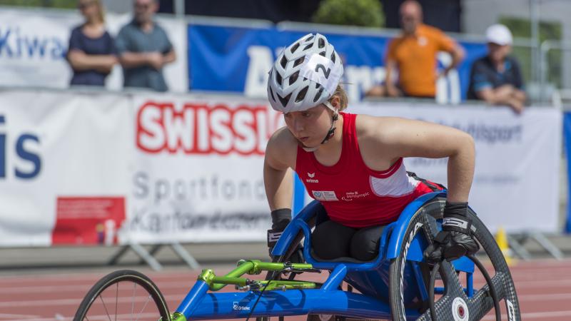 a female wheelchair racer lines up for the start of a race