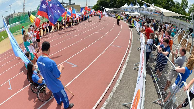 Teams holding flags on the track for Opening Ceremony