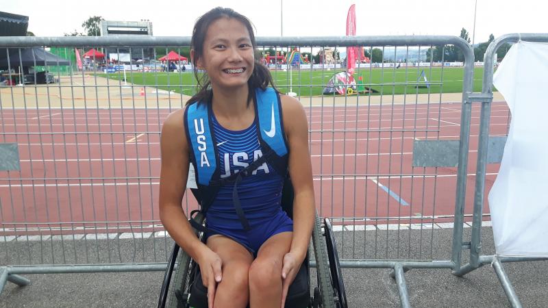 Girl in wheelchair smiles for a photo after her race