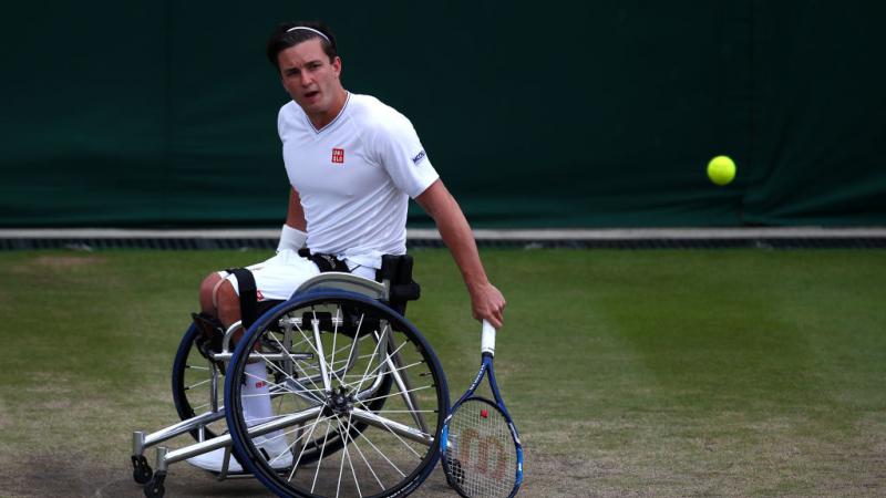 a wheelchair tennis player hits a shot