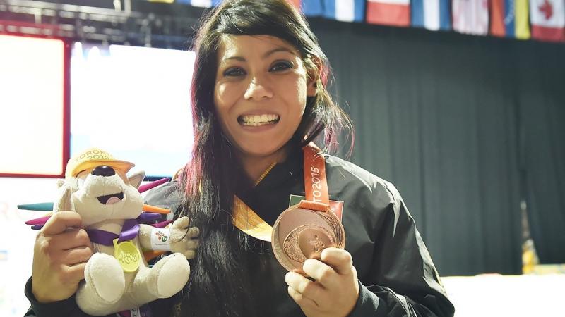 a Para athlete holds her medal and smiles