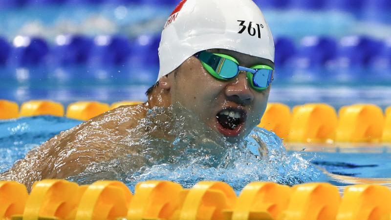 a Para swimmer takes a breath out of the water