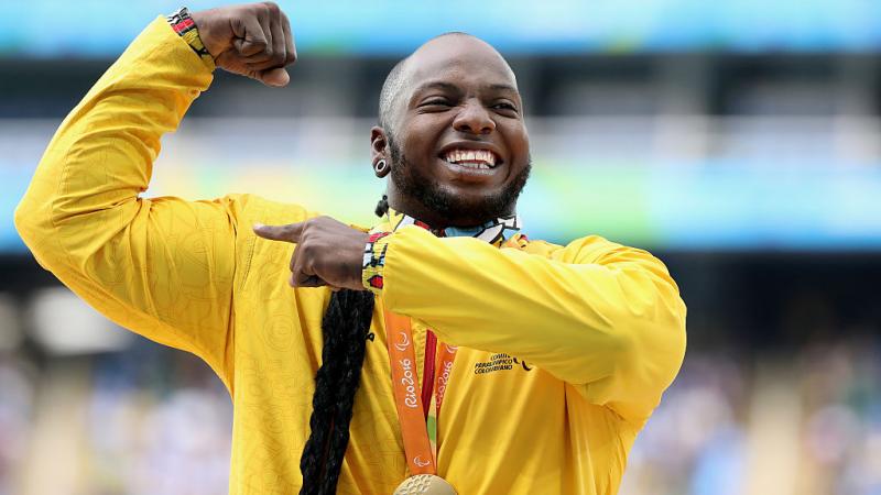 a man holds up his arms in celebration on the podium