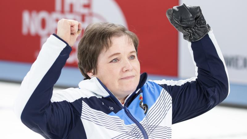 Female wheelchair curler raises her arms