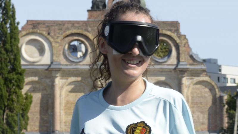 a female blind footballer smiles for the camera