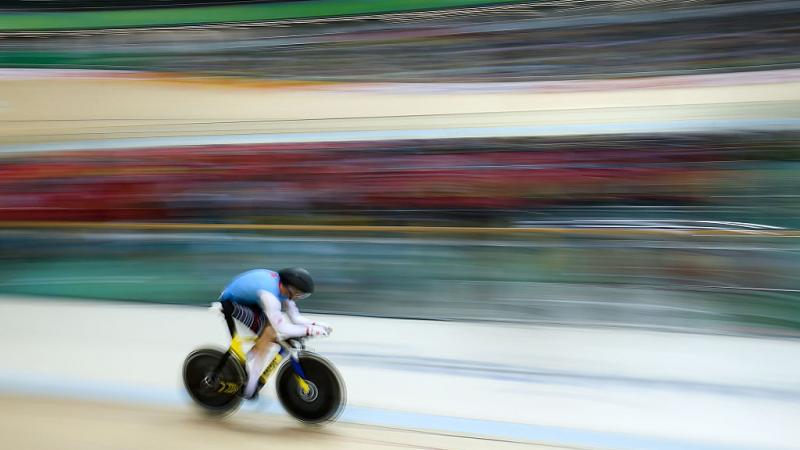 a Para cyclist speeds around the track