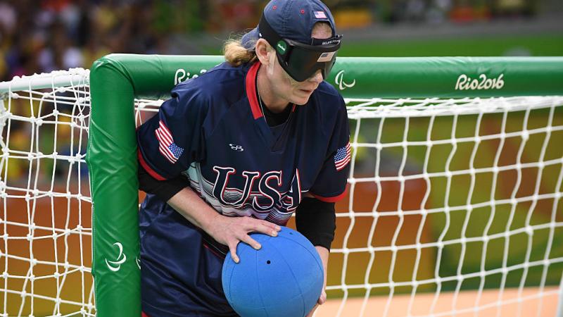 a female goalball player stands by the goal