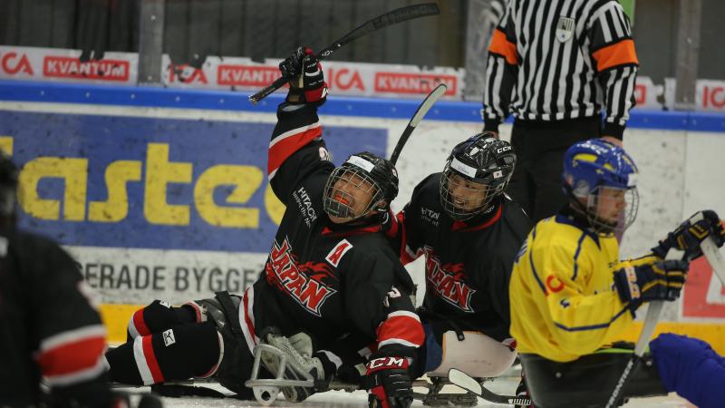 a group of Para ice hockey players celebrate a goal