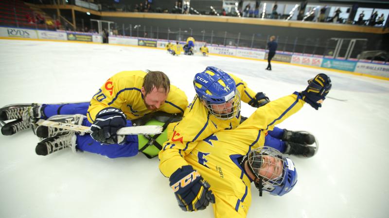 Para ice hockey players celebrate on the ice