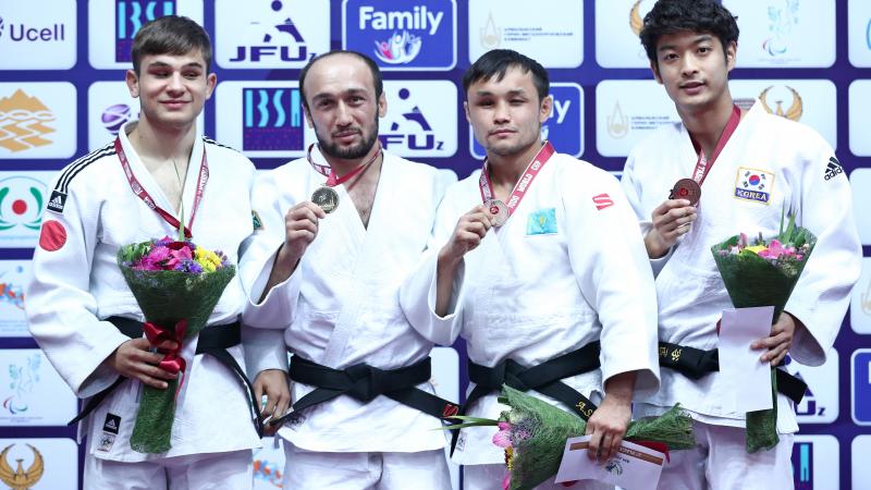 four Para judokas stand on the podium with their medals 