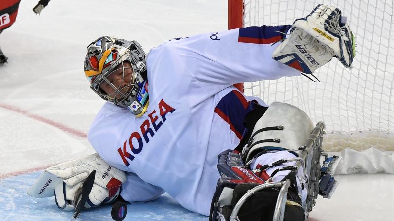 a male Para ice hockey player makes a save