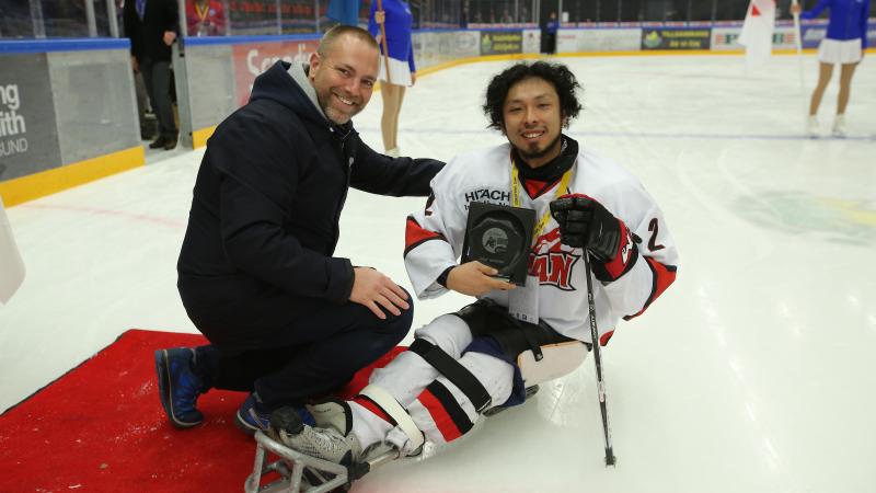 a male Para ice hockey player smiles after being presented with an award