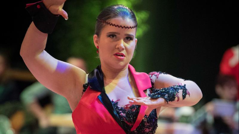 a female Para dance athlete shapes her arms