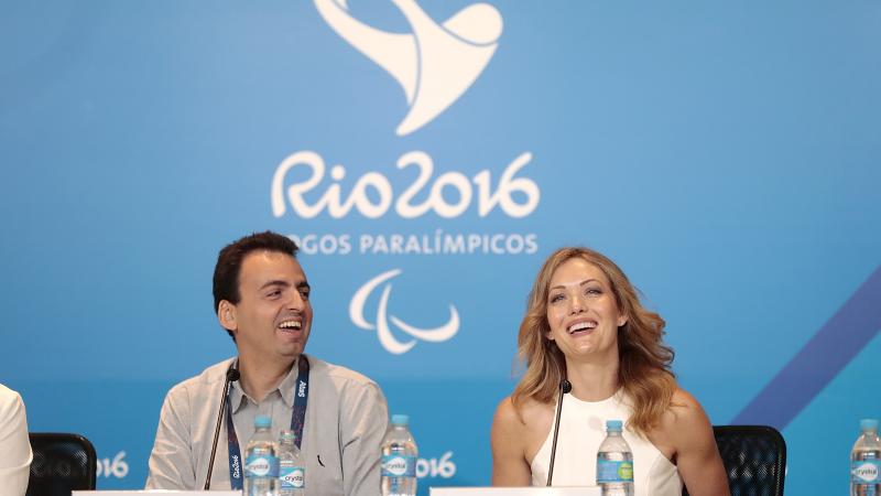a man and a woman answering questions at a press conference