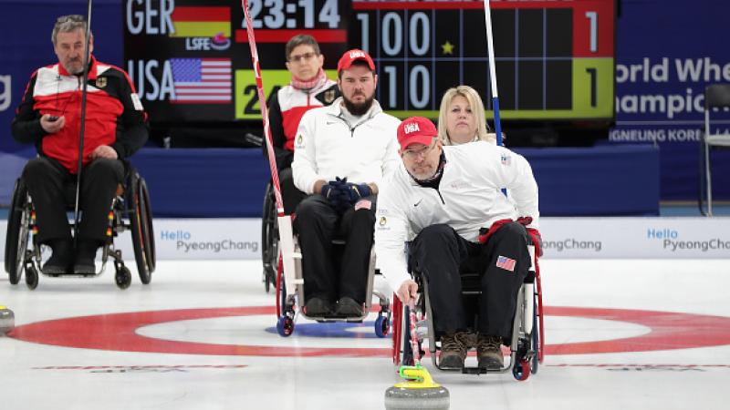 Wheelchair curlers competing on the ice
