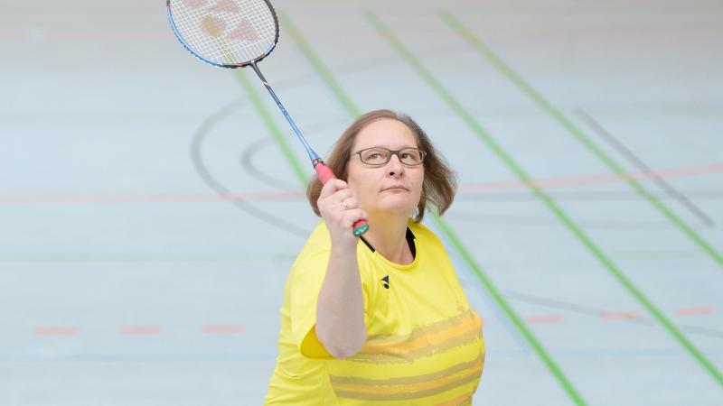 a female Para badminton player goes for a shot