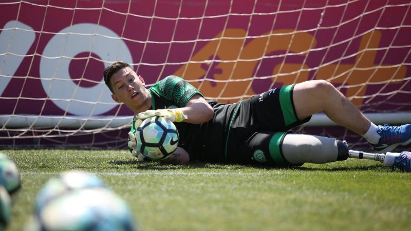 Person with a prosthetic leg practicing football as a goalkeeper