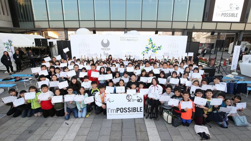 a group of schoolchildren holding up signs