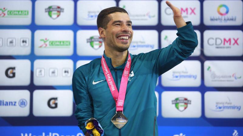 a male Para swimmer celebrates on the podium